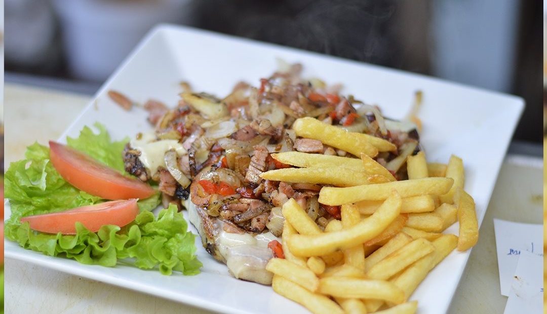 Carne salteada con cebolla y morrón, papas fritas y ensalada de lechuga y tomate